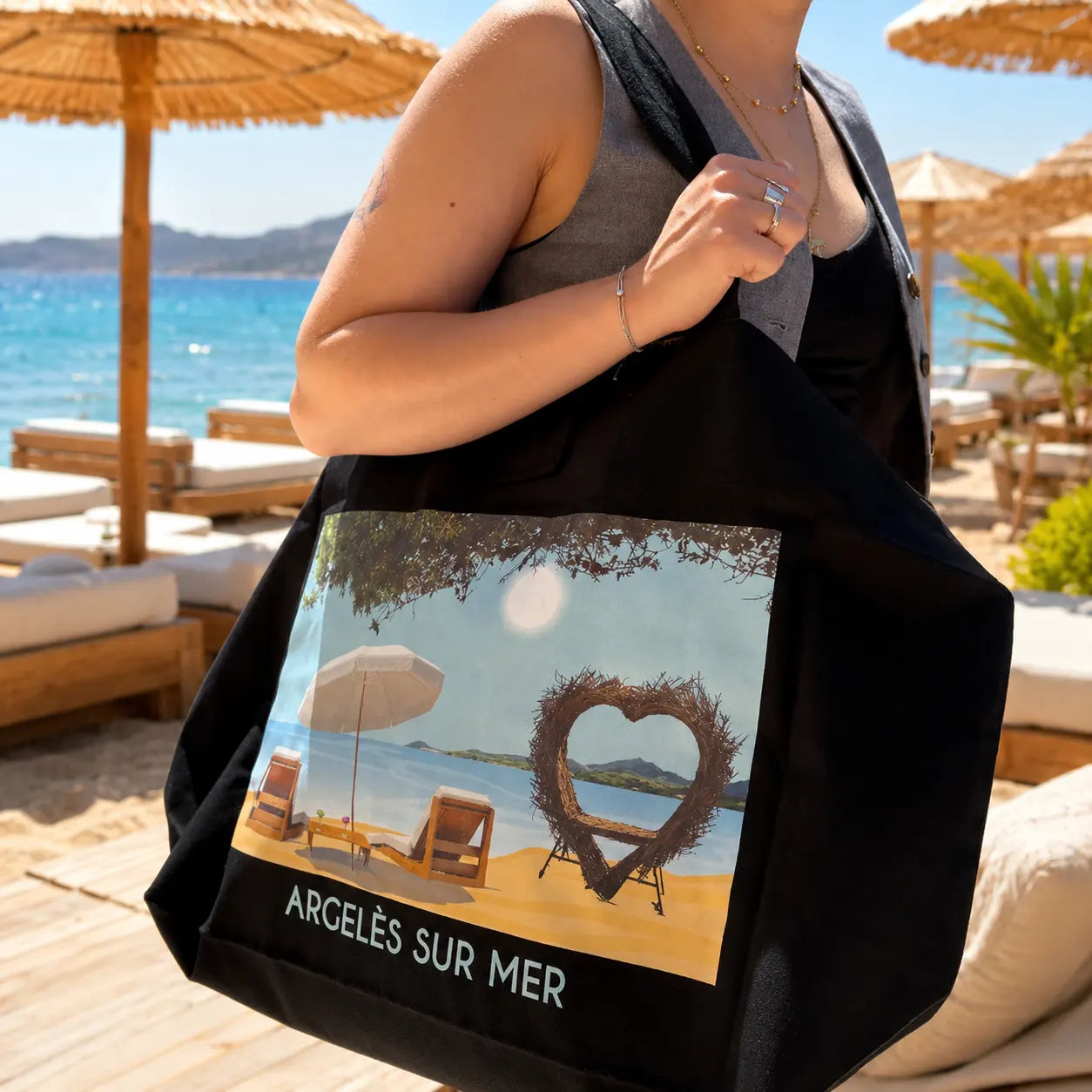 Cabas XXL Foliove Argelès-sur-Mer porté épaule sur plage, illustration cœur en bois flotté et transats